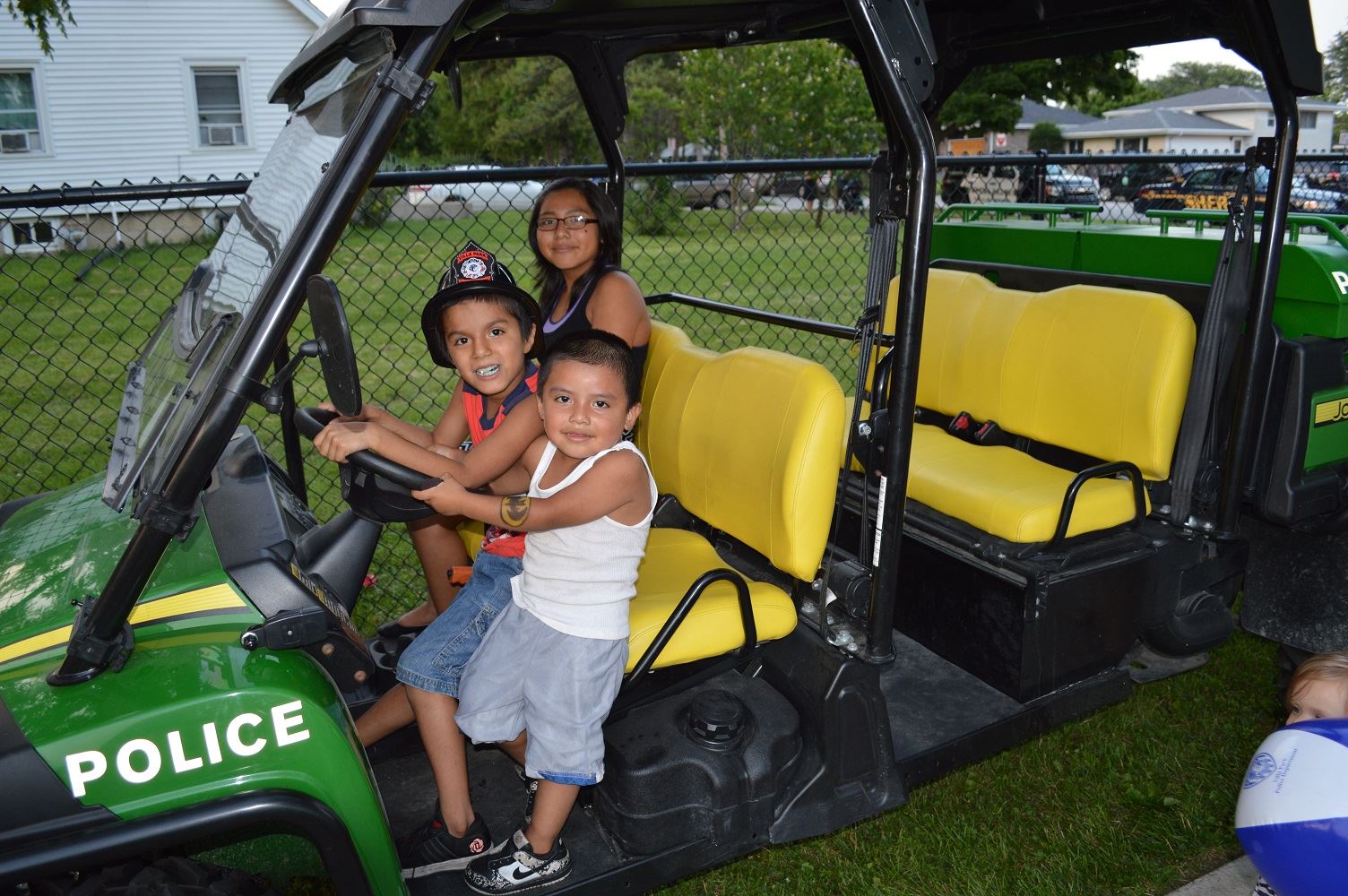 Three children check out the front seat of the Villa Park Police Gator vehicle during a National Night Out event at the Iowa Community Center, Aug. 2.